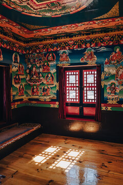 Sunlit Buddhist Monastery Interior with Ancient Murals and Mandala