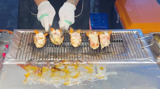 Korean Street Food &ndash; Grilling Whole Lobster in Shell on Hot Griddle at Outdoor Market Stall