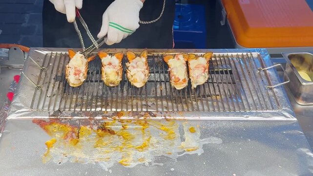 Korean Street Food &ndash; Grilling Whole Lobster in Shell on Hot Griddle at Outdoor Market Stall