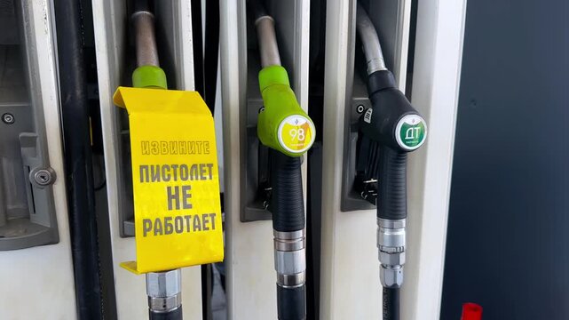 fuel dispenser nozzles at a gas station with a yellow out of order sign on one handle. Fuel shortage crisis, energy Fuel pump, unavailable service, 19.08.26 St.Petersburg Russia