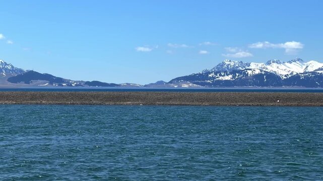 Beautiful scenic view of Sayram Lake with turquoise water and snow-capped Tianshan mountains in Xinjiang, China.