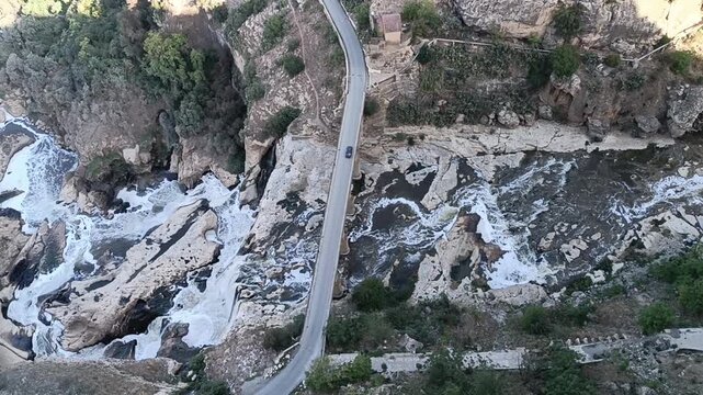 Aerial view of the bridge over the canyon in Constantine. Car crosses the river