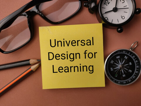 A yellow note reading Universal Design for Learning sits framed by glasses, pencils, clock, and compass