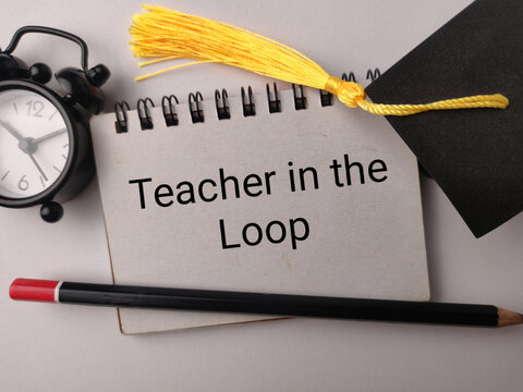 A notebook labeled Teacher in the Loop lies with a clock, graduation cap, and pencil on white