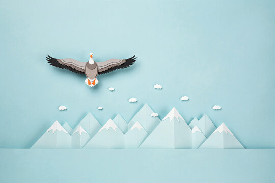 Minimalist paper cut style flying goose soaring over snowy mountain peaks under blue sky illustration