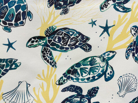 Marine-themed fabric pattern featuring stylized sea turtles, starfish, shells and coral in blue, teal and yellow tones on a light background. Decorative ocean textile design with coastal style.