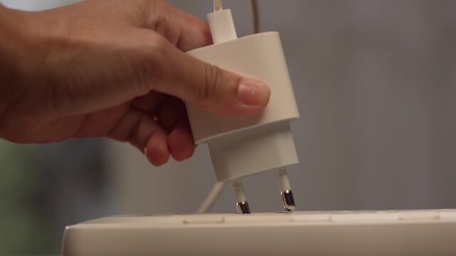Close up of woman hand failing to plug adapter into first socket then moving to second outlet, plugging it in and adjusting it firmly, solution concept.⁠