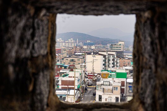 Suwon cityscape view through historic fortress wall embrasure