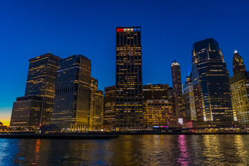 Naklejka premium City lights shimmer over New York's skyline as night descends