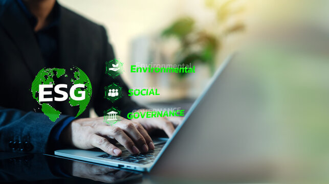 Businessman working on laptop with digital ESG (Environmental, Social, Governance) interface icons. Concept of sustainable business, corporate responsibility, and green energy management.
