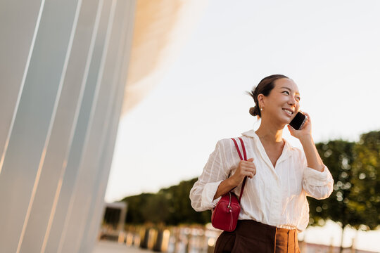 Korean woman enjoying a sunny day while chatting on her phone