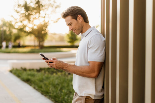 Enjoying a sunny moment while checking messages on a smartphone