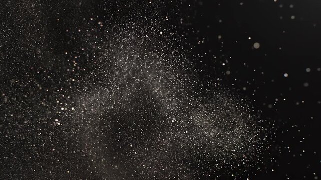 Fine particle dust cloud swirling in cinematic motion against a dark background with subtle sparkle