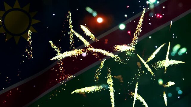 Bright colorful fireworks exploding in the night sky over the flag of Namibia