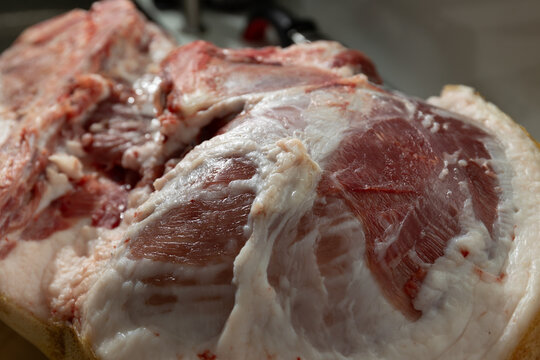 Raw pork leg bone-in in a home kitchen: authentic texture and unpolished butchery