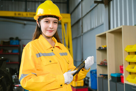 Engineers work conceptual framework for industrial engineering factory work joyful woman worker smiling happily inside manufacturing plant holding