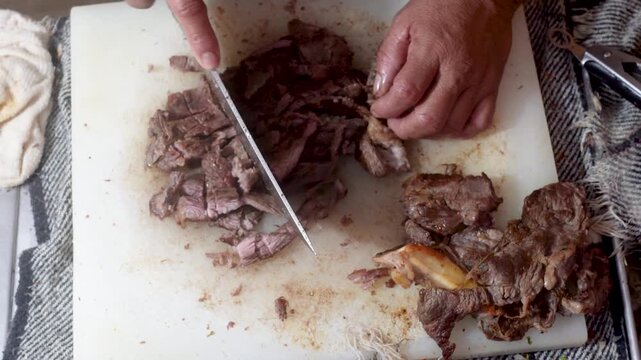 Female hands cutting meat at a taco stand. Mexican street food.