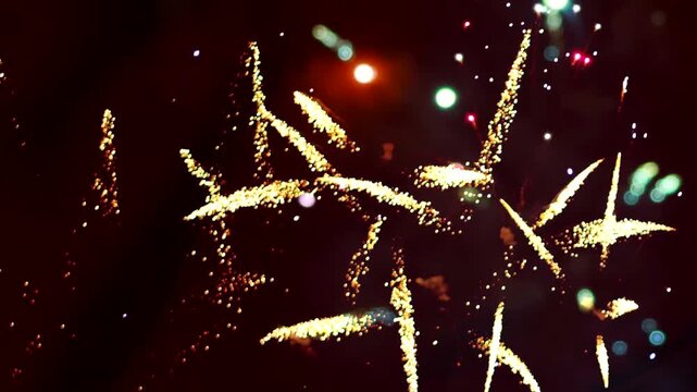 Bright golden fireworks exploding in the night sky during a celebration