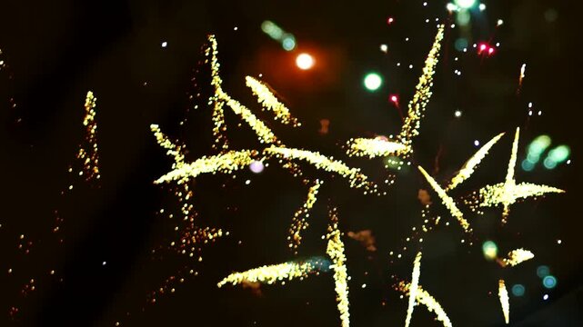 Bright golden fireworks exploding in the night sky during a celebration