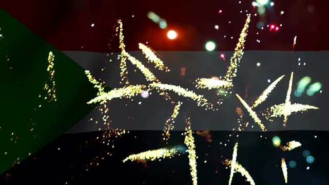 Bright golden fireworks exploding in the night sky over the national flag of Sudan