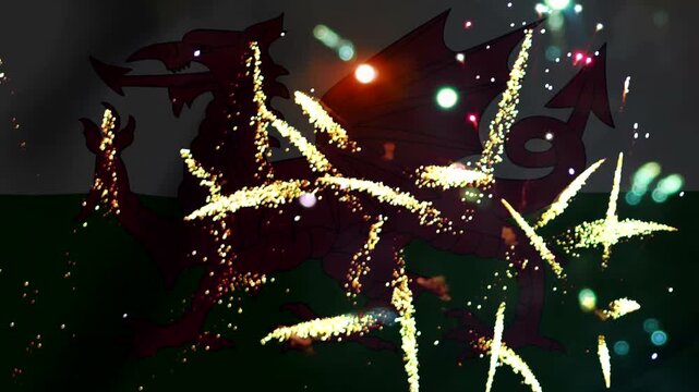 Bright golden fireworks exploding over the welsh flag featuring a red dragon on a green and white background