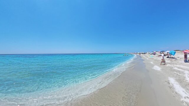 First person walking POV along Mari Ermi beach Sardinia with quartz sand and vibrant turquoise Mediterranean