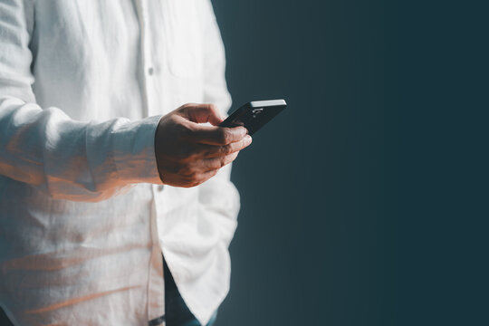 Adult man thinking while holding a mobile phone. Online shopping, chat, social media, customer service and payment. Modern smartphone technology concept.