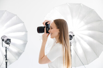 Young female photographer with professional camera working in studio © F8  \ Suport Ukraine