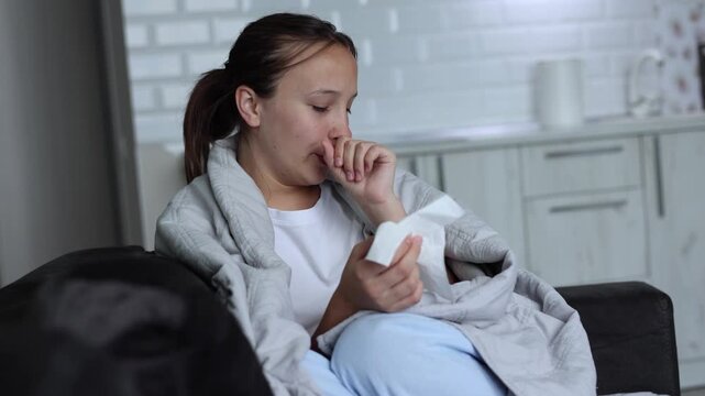 Sick girl with runny cold symptoms resting at home, representing illness, flu and seasonal infection