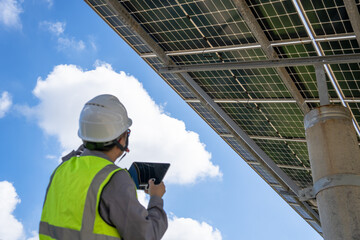 Engineer inspecting solar panel system with digital tablet outdoors © Xianshu