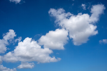 Fototapeta premium Bright White Cumulus Clouds Against Deep Blue Sky