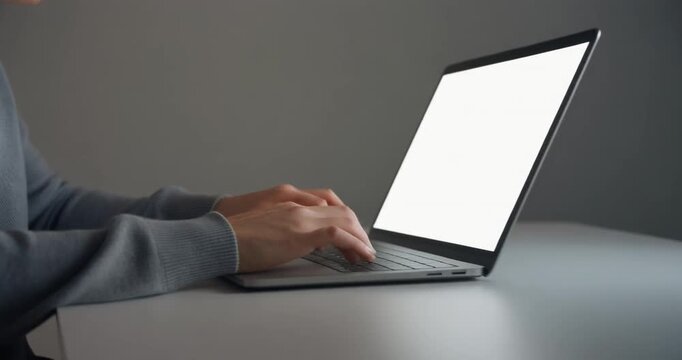 Person typing on slim laptop with blank screen for remote education task