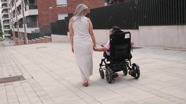 Woman holding hands with disabled man in wheelchair