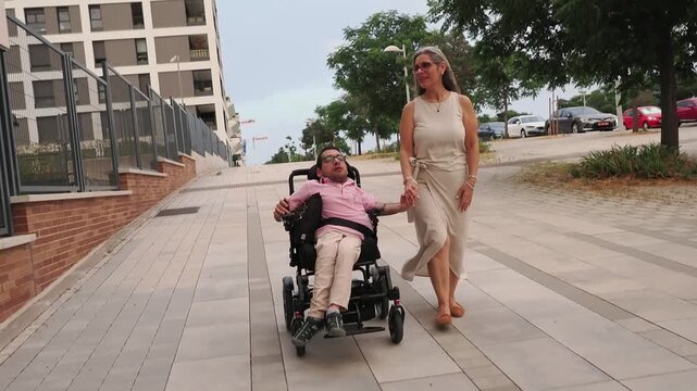 Disabled man in wheelchair and woman holding hands