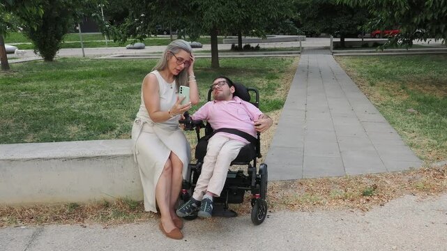 Mother and disabled son taking selfie in a park