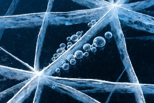 Close-up of ice crystals with trapped air bubbles forming a geometric pattern