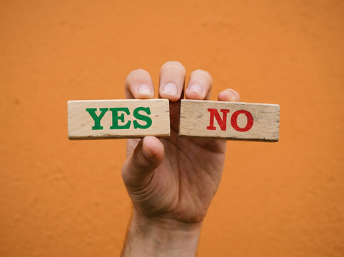 Hand holding wood blocks with yes and no