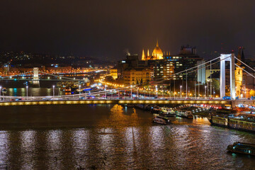 Fototapeta premium A breathtaking nighttime cityscape panorama of Budapest across the Danube river highlighting iconic historical architecture and illuminated modern bridge structures in Hungary