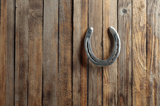 Old horseshoe on a wooden background.