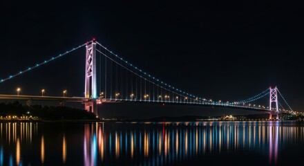 Fototapeta premium Magnificent suspension bridge illuminated at night with vibrant reflections in dark water