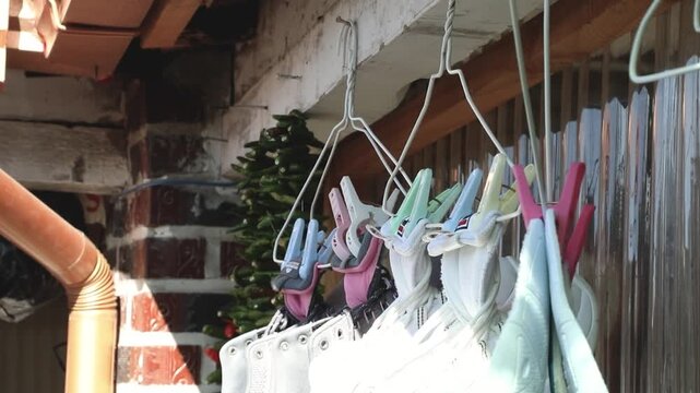 처마 아래 빨래걸이에 신발 집게로 매달려 건조되고 있는 운동화들과 소박한 일상의 풍경