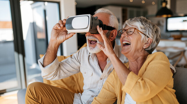 Senior couple enjoying virtual reality experience together, laughing and having fun with modern technology at home