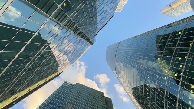 Modern skyscraper with unique architectural design featuring a large cutout, showcasing reflective glass surfaces and angular lines against a clear blue sky