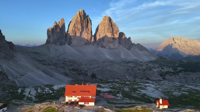 Backward Drone Flight Over Tre Cime at Sunrise with Locatelli Refuge

