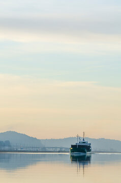 Freight ship moves along river Gota Alv in Sweden during early morning hours