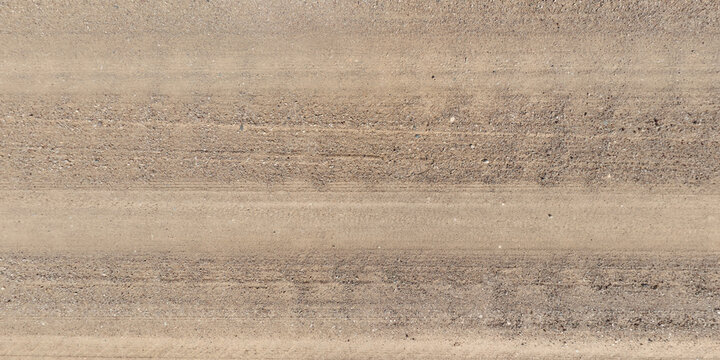 view from above on texture of gravel road among grass field