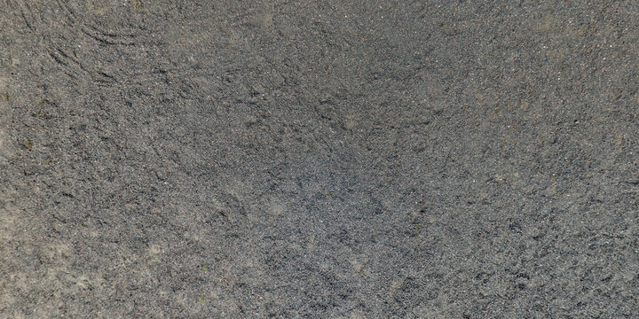 view from above on texture of gravel road among grass field