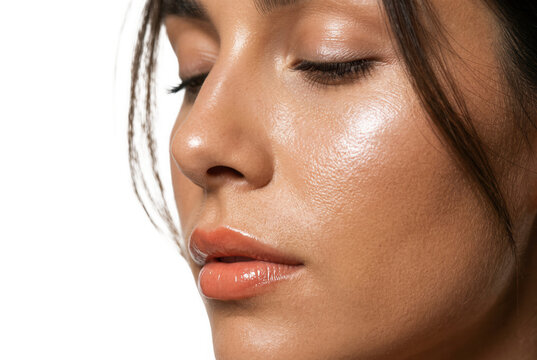 Gros plan sur le visage d'une jeune femme avec une peau &eacute;clatante et naturelle, mettant en valeur un teint frais, des l&egrave;vres brillantes et une texture de peau saine et hydrat&eacute;e.