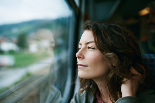 Young Woman Looking Out Window During Train Travel