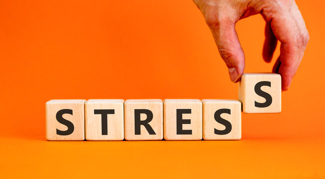 Stress word symbol. Concept word Stress on beautiful wooden blocks. Beautiful orange background. Psychologist's hand. Business psychological medical stress word concept. Copy space.